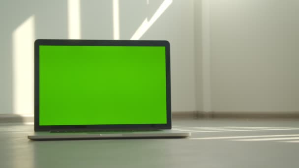 Primo piano sparare del computer portatile con schermo verde posa sul tavolo in ufficio al chiuso — Video Stock