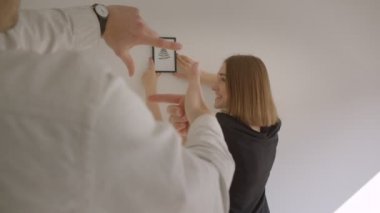 Yeni bir rahat dairede hareket genç mutlu çift Closeup portre. Kadın bir resim tutan ve mutlu bir şekilde gülerek onun yerleşimkarar