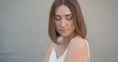 Kapalı beyaz odada kamera önünde poz saç halkaları ve glitter makyaj ile genç güzel beyaz kadın Closeup ateş