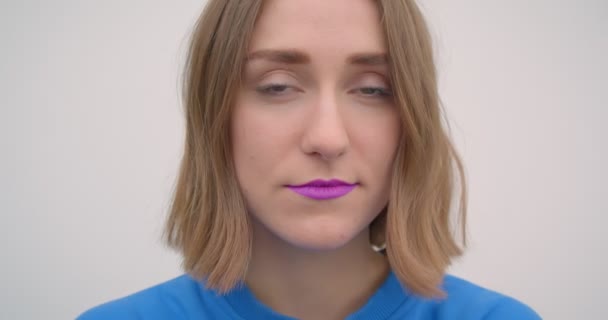 Mor ruj ile genç kısa saçlı kadın closeup portre kamera arka plan beyaz izole bakarak — Stok video