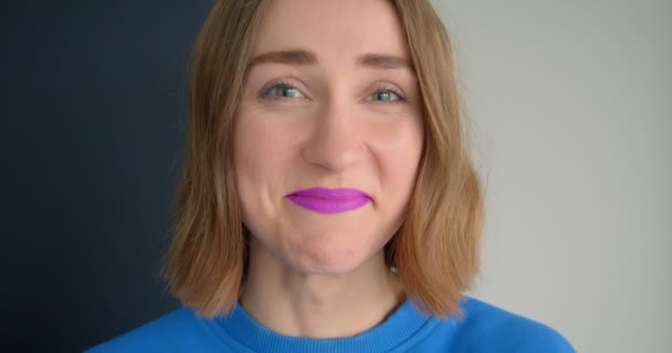 Nahaufnahme Porträt einer jungen kurzhaarigen Frau mit glamourösem lila Lippenstift, die glücklich lachend in die Kamera blickt — Stockvideo