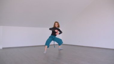Genç güzel yetenekli kadın bir düz kapalı boş odada duygusal bir dans performans Motion shoot