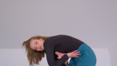 Genç sevimli yetenekli kadın bir düz kapalı boş odada kamera bakarak duygusal bir dans performans Closeup ateş