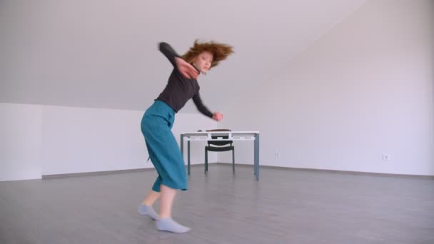 Motion shoot of young beautiful skilled female dancer performing with flexibility in the room indoors — Stock Video