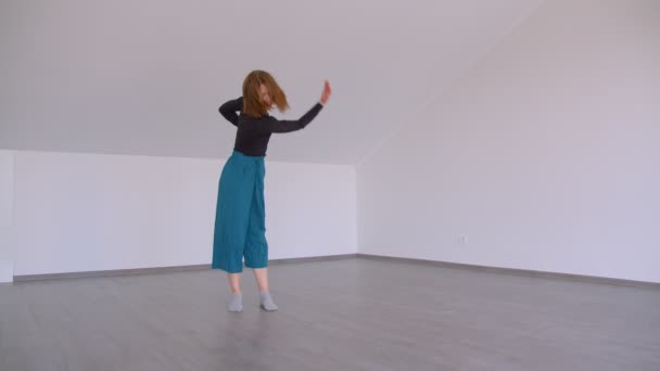 Pohyb mladé krásné kvalifikované ženy, která provádí emocionální tanec v místnosti uvnitř bytu v ploché — Stock video