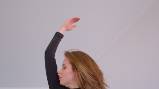 Primo piano di tiro di giovane carina donna abile eseguire una danza emotiva nella stanza vuota al chiuso in un appartamento — Video Stock
