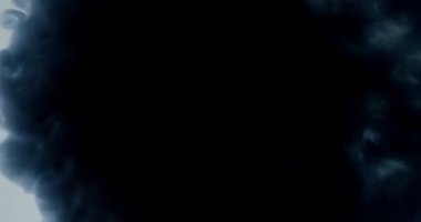 Gri suluboya mürekkebi sıçramave koyu dumanlı buluta dönüşen bir sıvı nın içinde düşmenin yakın çekim çekimi