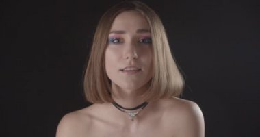 Siyah izole arka plan ile kamera bakarak utangaçlık ile gülümseyen sevimli makyaj ile genç güzel kafkas kısa saçlı kadın Closeup ateş