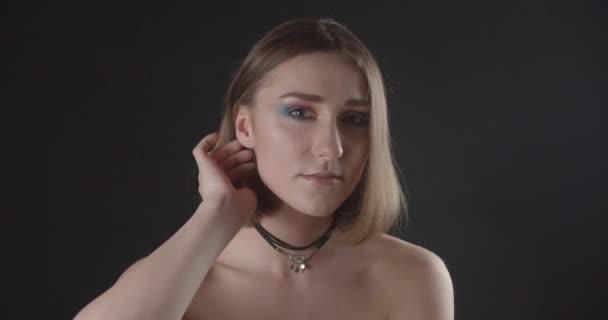 Nahaufnahme Shooting von jungen hübschen kaukasischen kurzhaarige Frau mit niedlichen Make-up und nackten Schultern Blick auf Kamera mit Hintergrund isoliert auf schwarz — Stockvideo