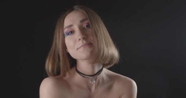 Closeup shoot of young pretty caucasian short haired female with cute makeup smiling and laughing happily looking at camera with background isolated on black — Stock Video