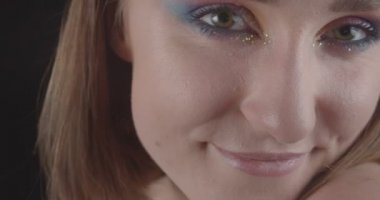 Siyah arka plan izole arka plan ile gülümseyen kamera bakarak sevimli glitter makyaj ile genç büyüleyici kafkas kısa saçlı kadın yüzü Closeup portre