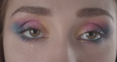 Siyah izole arka plan ile kamera bakarak glitter makyaj ile genç güzel beyaz kısa saçlı kadın yüzü Closeup ateş