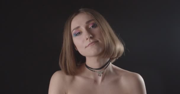 Närbild shoot av unga söta kaukasiska korthårig hona med söt makeup titta på kamera med bakgrund isolerad på svart — Stockvideo