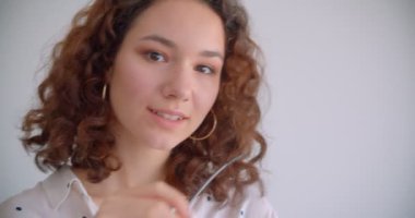 Gözlüklü genç oldukça uzun saçlı kıvırcık beyaz kadın closeup portre neşeyle beyaz izole arka plan ile kameraya bakarak gülümseyerek