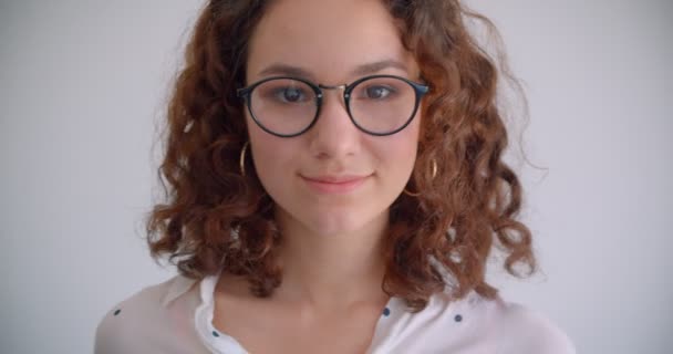 Closeup portrait of young sexy long haired curly caucasian female in glasses smiling seductively looking at camera with background isolated on white — Stock Video