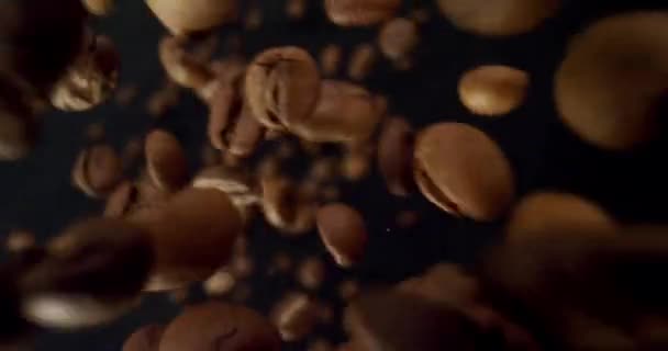 Gros plan pousse de grains de café en détail étant laissé tomber avec fond isolé sur noir 