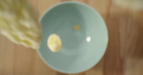Съемка крупным планом кукурузных хлопьев, брошенных в миску на столе — стоковое видео