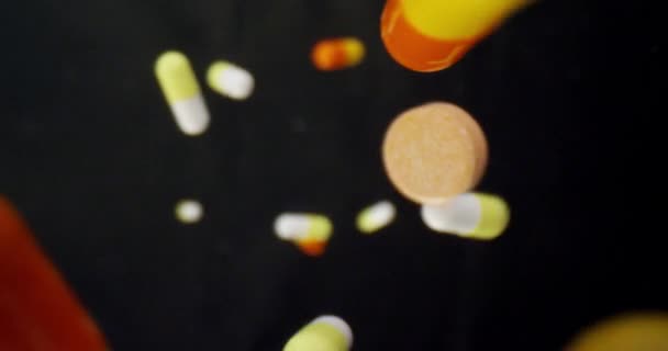 Tiro de close-up de pílulas médicas para gripe sendo descartado com fundo isolado em preto — Vídeo de Stock
