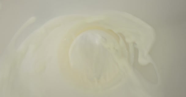 Closeup atirar de leite sendo derramado na tigela com flocos de milho na mesa — Vídeo de Stock