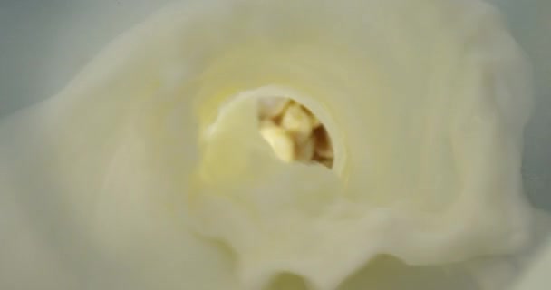 Closeup tiro superior de leite sendo derramado na tigela com flocos de milho na mesa — Vídeo de Stock