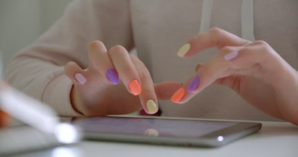 Primer plano de brote de manos femeninas con hermosa manicura escribiendo en la tableta en el interior de la oficina — Vídeos de Stock