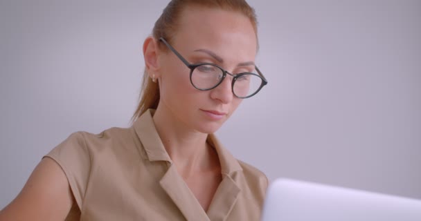 Primer plano de elegante mujer de negocios caucásica escribiendo en el ordenador portátil sonríe en la cámara en la oficina blanca . — Vídeos de Stock