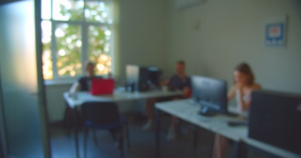 Boven uitzicht schieten van zakenlui zittend in het kantoor en het gebruik van de laptop binnenshuis met vage focus — Stockvideo