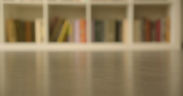 Shoot of the bookshelves with books in the library with modern interior indoors with blurred background — Stock Video