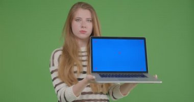 Dizüstü bilgisayarı kullanarak ve kameraya mavi ekran gösteren genç güzel beyaz kadın Closeup ateş