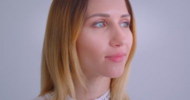 Beyaz üzerine izole arka plan ile kameraya bakarak neşeyle gülümseyen genç güzel beyaz kadın Closeup portre