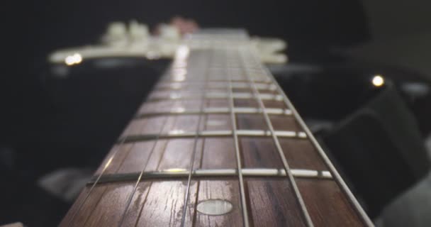 Siyah izole arka plan ile bir müzisyen tarafından tutulan dizeleri ile eski gitar Closeup ateş — Stok video