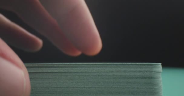 Closeup střílej z mužské ruky s kartou z paluby v pokrového zápase s pozadím izolovaným na černém — Stock video