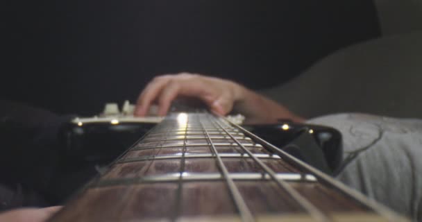 Närbild shoot av gitarr med strängar som håller av en musiker med bakgrund isolerade på svart — Stockvideo