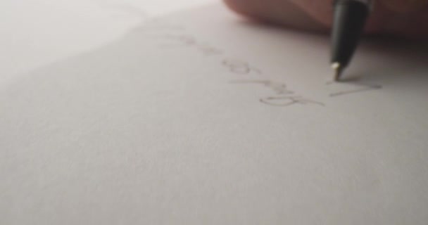 Primo piano colpo di mano scrivere una lettera sulla carta con una penna. Scrittura a mano sul foglio — Video Stock