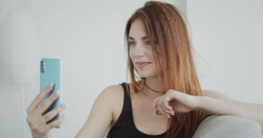 Siyah bodysuit genç seksi kafkas kadın closeup ateş telefonda duygusal kanepede kapalı oturan konuşurken bir görüntülü arama olan
