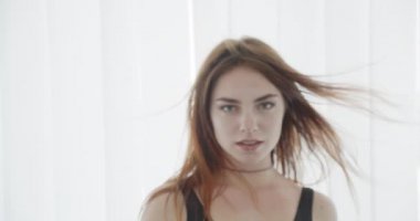 Siyah bodysuit genç seksi kafkas kadın closeup çekim kamera bakıyor ve beyaz izole arka plan ile mutlu bir şekilde gülümseyerek