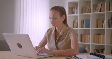 Şık beyaz iş kadını ofiste meşgul dizüstü yazma.