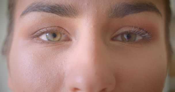 Zbliżenie Portret młodej atrakcyjnej kobiecej twarzy z oczami patrząc na kamerę — Wideo stockowe
