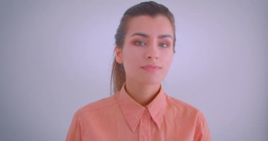 Genç güzel beyaz kadın dönüm ve izole arka plan ile mutlu bir şekilde gülümseyen kamera bakarak Closeup portre