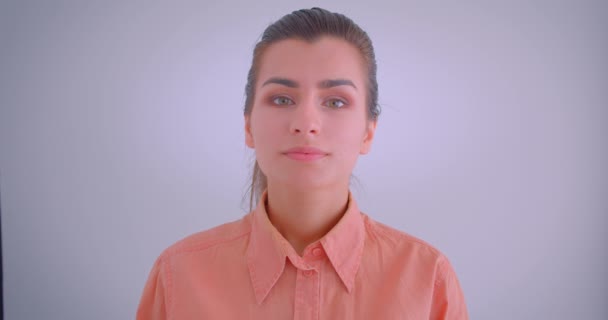 Closeup portrét mladé bělošské ženské, která se dívá na fotoaparát s izolovaným pozadím — Stock video