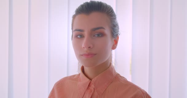 Closeup portrét mladé atraktivní ženské tváře s radostí s pohledem na kameru v kanceláři v interiéru — Stock video