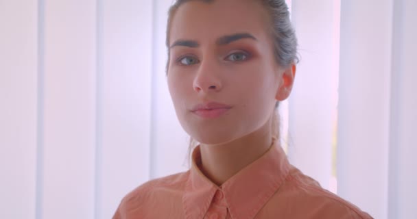 Closeup portrait of young attractive businesswoman face looking at camera in the office indoors — Stock Video