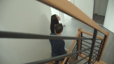 Beyaz çift merdivenleri tırmanıyor ve yeni bir daire ye bakıyor.