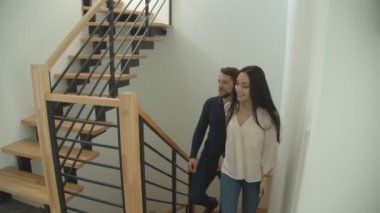 Bin yıllık beyaz çift, yeni satın alınan bir eve bakarak el ele tutuşarak merdivenleri tırmanıyor..