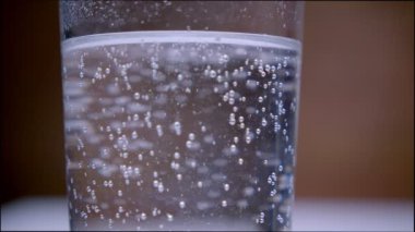 Şeffaf bir cam kabarcıklar ile fizzing gazlı su Closeup makro ateş