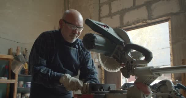Obermeister bei der Arbeit in der Holzfabrik mit Stirnsäge und Lineal konzentriert und ernst. — Stockvideo