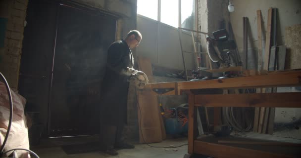 Perfil de disparo de maestro masculino senior trabajando en la fabricación de molienda de la tabla de madera que se concentra . — Vídeo de stock