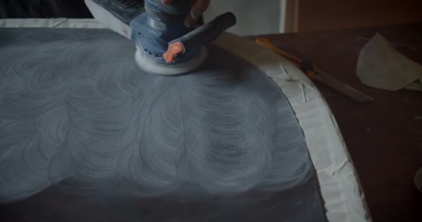 木製のボードを磨き、木工工場でパターンを作るために研削機を使用して手のクローズアップショット. — ストック動画