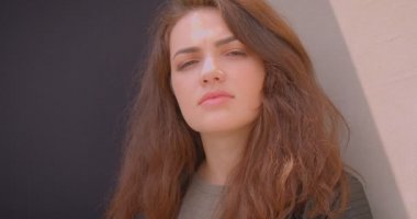 Blck ve beyaz arka plan üzerinde sakin ve rüya gibi açık havada kameraya izlerken ciddi esmer kız Portresi.