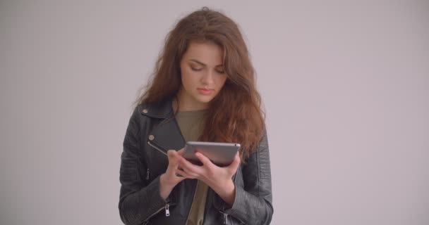 Model Brunette bekerja dengan tablet yang sibuk terisolasi pada latar belakang putih . — Stok Video